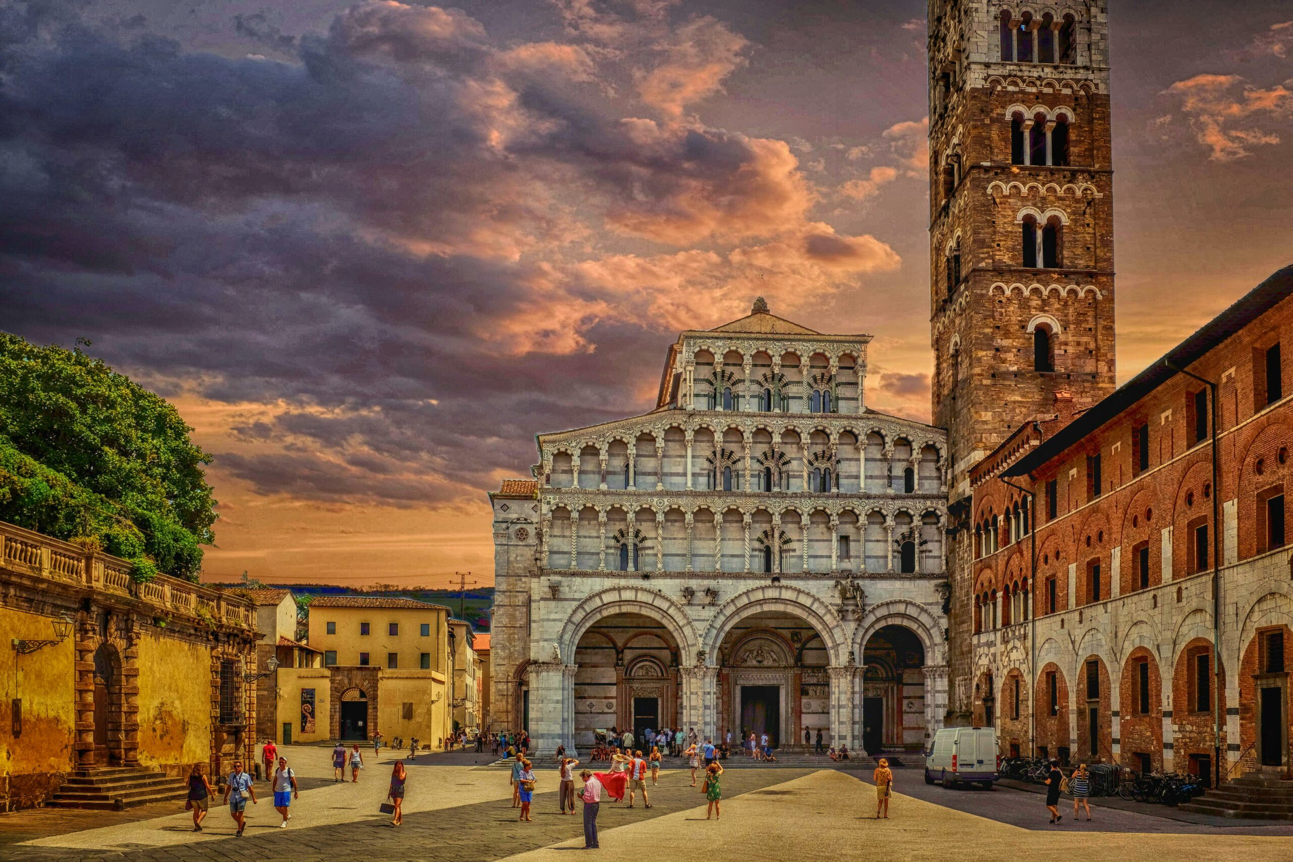 Capture of Lucca Cathedral at sunset, showcasing gothic architecture and bustling tourists.